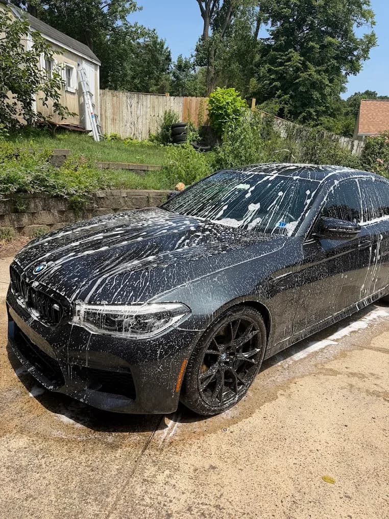 BMW covered in foam during a DMV Luxury Detail mobile wash