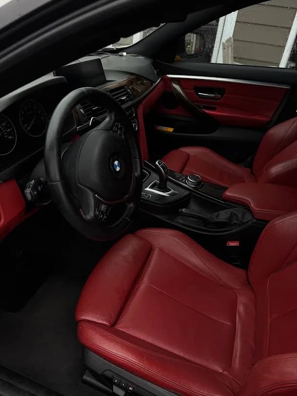 Freshly detailed red leather BMW interior photographed from the driver door